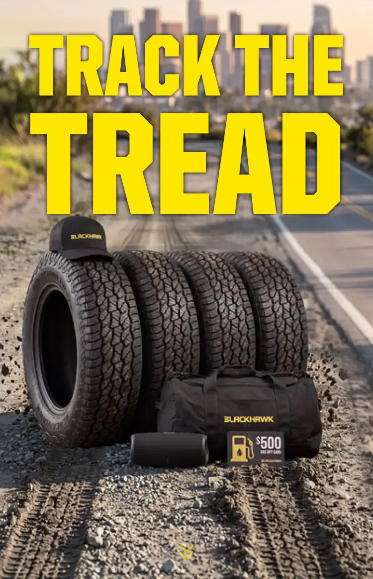 Promotional banner featuring the headline "TRACK THE TREAD" in large yellow lettering over a rugged dirt road leading toward a distant city skyline. On the right, four Blackhawk all-terrain tires are displayed alongside a Blackhawk-branded cap, duffel bag, rolled mat, and a $500 gas gift card. Tire tracks run through the foreground, reinforcing the off-road theme.